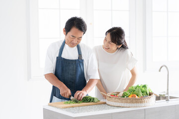 料理をする夫と見守る妻 © folyphoto