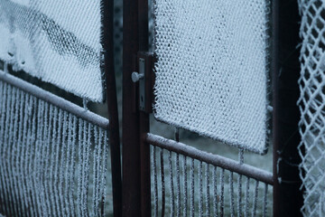 A frostcovered gate stands as a stark reminder of winters chill, evoking feelings of isolation and...