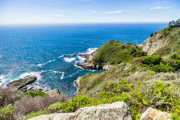 Stunning coastal landscape along California's Highway 1, featuring rugged rocky formations, and the vast blue ocean. A breathtaking natural scene showcasing the raw beauty of the Pacific coastline