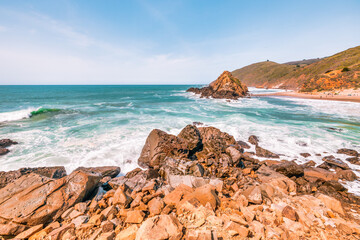 Stunning coastal landscape along California's Highway 1, featuring rugged rocky formations, and the vast blue ocean. A breathtaking natural scene showcasing the raw beauty of the Pacific coastline
