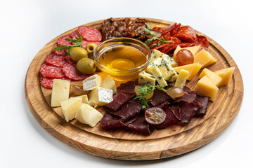Wooden plate with sausages, ham, salami 