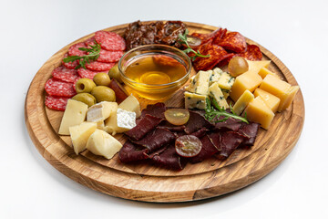 Wooden plate with sausages, ham, salami 