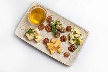 Cheese platter with olives, grapes, nuts and honey