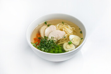 Chicken soup with noodles and vegetables in a bowl isolated on white background