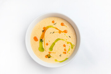 Creamy soup in a white bowl on a white background.