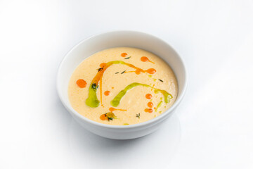 Creamy soup in a white bowl on a white background.