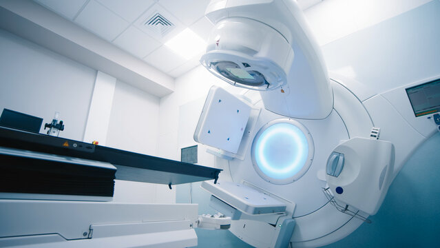 Empty radiotherapy treatment room with linear accelerator ready for use. The clean, modern medical environment showcases advanced cancer treatment technology and precision equipment for patient care