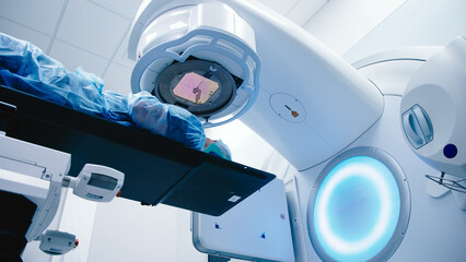 A patient undergoing radiation therapy. Medical linear accelerator in therapeutic oncology. The...