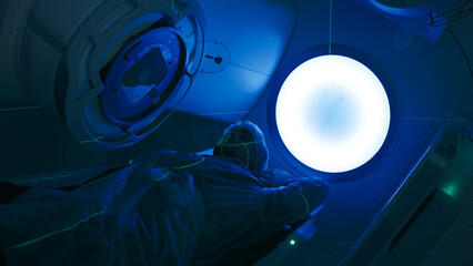 Cancer treatment in a modern medical private clinic or hospital using a linear accelerator. A young...