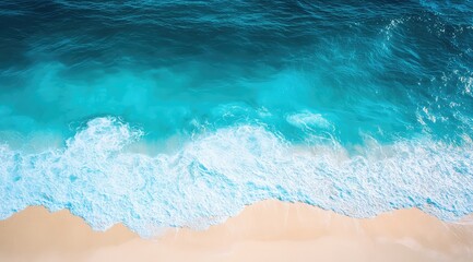 Aerial view of ocean waves crashing on a sandy beach.  Turquoise water meets pale sand
