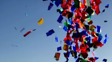 Vibrant confetti explosion against blue sky showcasing festive celebration