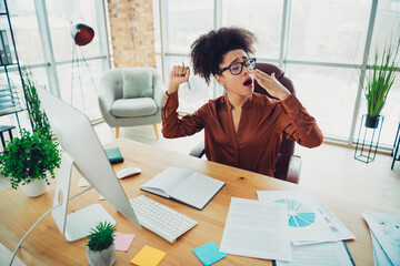 Young businesswoman yawning stylish loft office workspace professional casual fashion working...