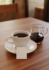 Obraz premium a simple white ceramic coffee cup and saucer on a wooden table, filled with black coffee. Next to the cup is a small clear glass carafe also containing black coffee