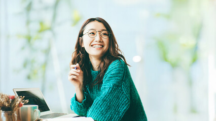 ノートパソコンを使う笑顔の女性