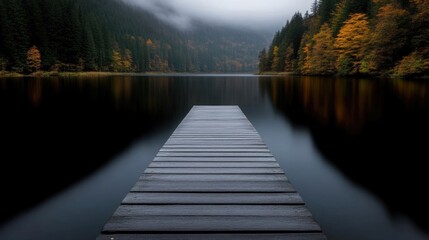 Tranquil wooden pier extending into a serene lake, surrounded by misty autumnal forest