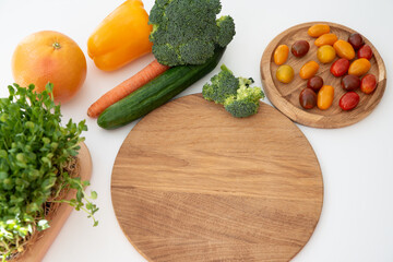 Bright culinary ingredients, vegetables and microgreens are laid out on the table near the wooden cutting board. Healthy Eating