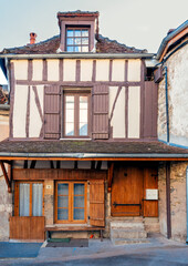 Old building facade featuring wooden door, iron balcony, and geometric stone wall pattern.For the...
