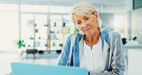 Obraz premium Business, mature woman and laptop in office for accounting, finance research and reading report. Smile, female person and online with financial management, audit payroll and review budget for company