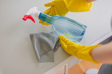 Cropped hands cleaning a table at home