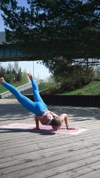 Fit Caucasian Woman in White Top Doing Low Balances on Park Terrace