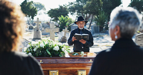 Bible, coffin and pastor by graveyard with people for spiritual farewell, grief or loss. Religion,...