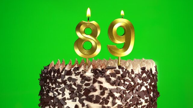 Burning candles number 89 on birthday cake against chroma key background. Eighty-ninth birthday. Birthday celebration