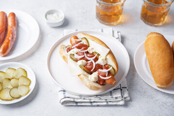 Pickled cucumbers fresh onion frankfurter sausage hot dog sandwich on a white background