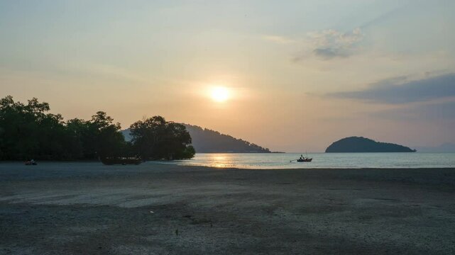 Timelapse stunning scenery of the coastal during sunset. Fast motion footage of the coast during low tide with dramatic sky and traditional fishing boats sailing on the sea. Koh Yao Yai. Thailand