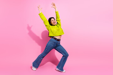 Plakat Cheerful young woman showcasing trendy style with vibrant attire and joyful expression in a colorful studio setting
