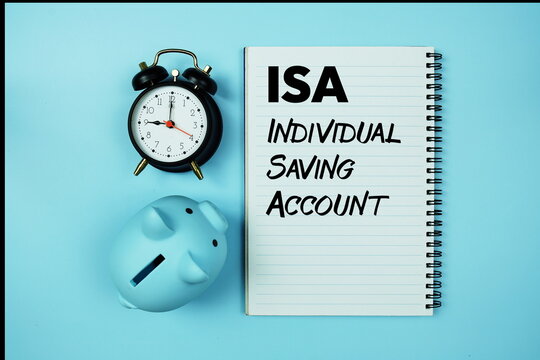 ISA abbreviation of Individual Saving Account text on notebook paper and piggy bank and alarm clock on blue background