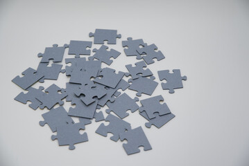 Puzzle pieces in a pile on a white background. Close-up