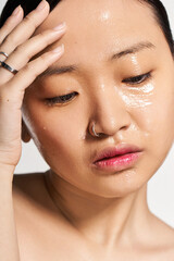 Obraz premium Glowing skin and serene expression of a young beautiful Asian woman in a calming beauty routine