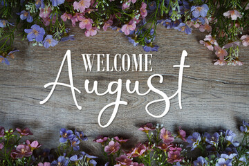 Welcome August text with flowers frame on wooden background