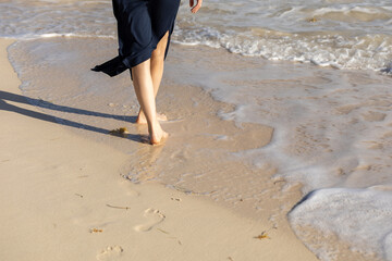 Walking barefoot along the shoreline during a sunny afternoon at the beach