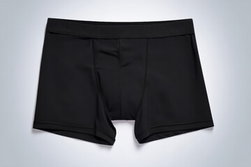 Close-up of a pair of black boxer briefs against a gradient gray backdrop.