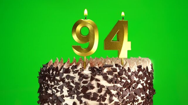 Burning candles number 94 on birthday cake against chroma key background. Ninety-fourth birthday. Birthday and anniversary celebration