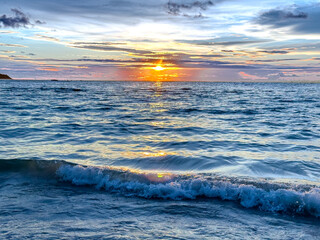 Colourful Sunset at Patong Beach in Phuket Thailand. Patong beach on Lovely island of Phuket where the waters are turquoise blue, lush green mountains colourful skiesP