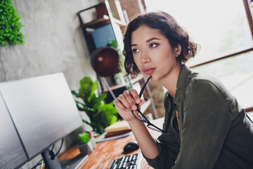 Young woman in a casual setting working with a computer, demonstrating focus and engagement in a professional workspace environment