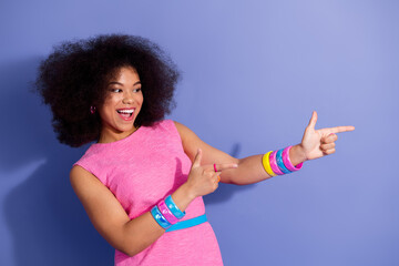 Cheerful young stylish woman gesturing with her hands in a trendy retro inspired pink dress against...