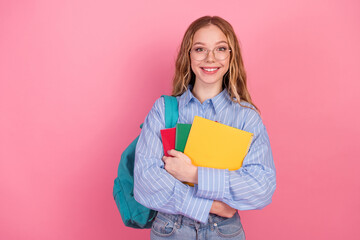 Happy Student in Stylish Blue Shirt Holding Notebooks Against a Pink Background