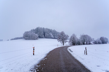 Winding gravel road through serene snowy landscape in winter