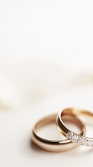 Elegant golden wedding rings with diamonds on a soft white surface capturing a moment of love and commitment in a bright and clean studio shot with a shallow depth of field