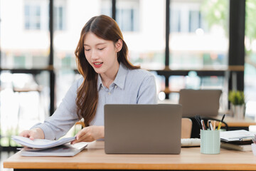 Fototapeta premium Young Woman Working at Desk with Laptop