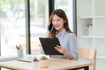 Young Woman Talking on Phone at Desk
