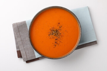 Tomato Soup garnished with pepper powder served in ceramic bowl