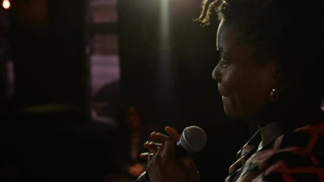 Close-up shot of African American woman interacting with audience from stage during her stand-up performance