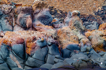 Rock face of hardened volcanic lava and stone on Mexican coast of Coronado Island, rough patterns on surface, black tinged with yellow, Loreto Bay National Marine Park, Baja California Sur, Mexico