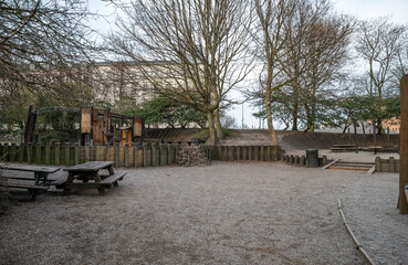 Community Playground in Urban Park Surrounded by Trees and Wooden Fence, Copenhagen, Denmark, 16 April 2018