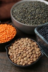 Different types of lentils on wooden table, closeup