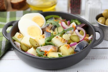 Delicious salad with herring, egg and vegetables on white wooden table, closeup
